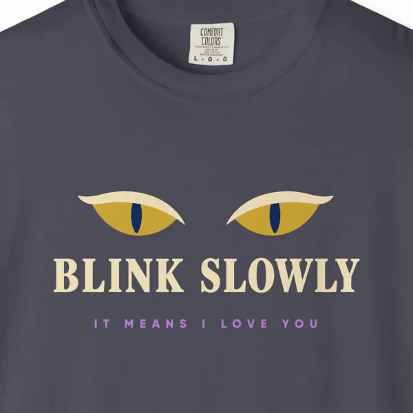 Close-up of the Blink Slowly print on a Navy Comfort Colors 1717 tee