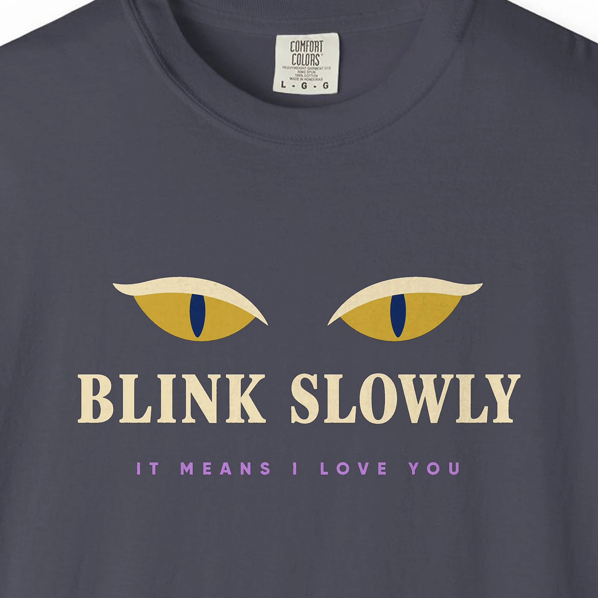 Close-up of the Blink Slowly print on a Navy Comfort Colors 1717 tee