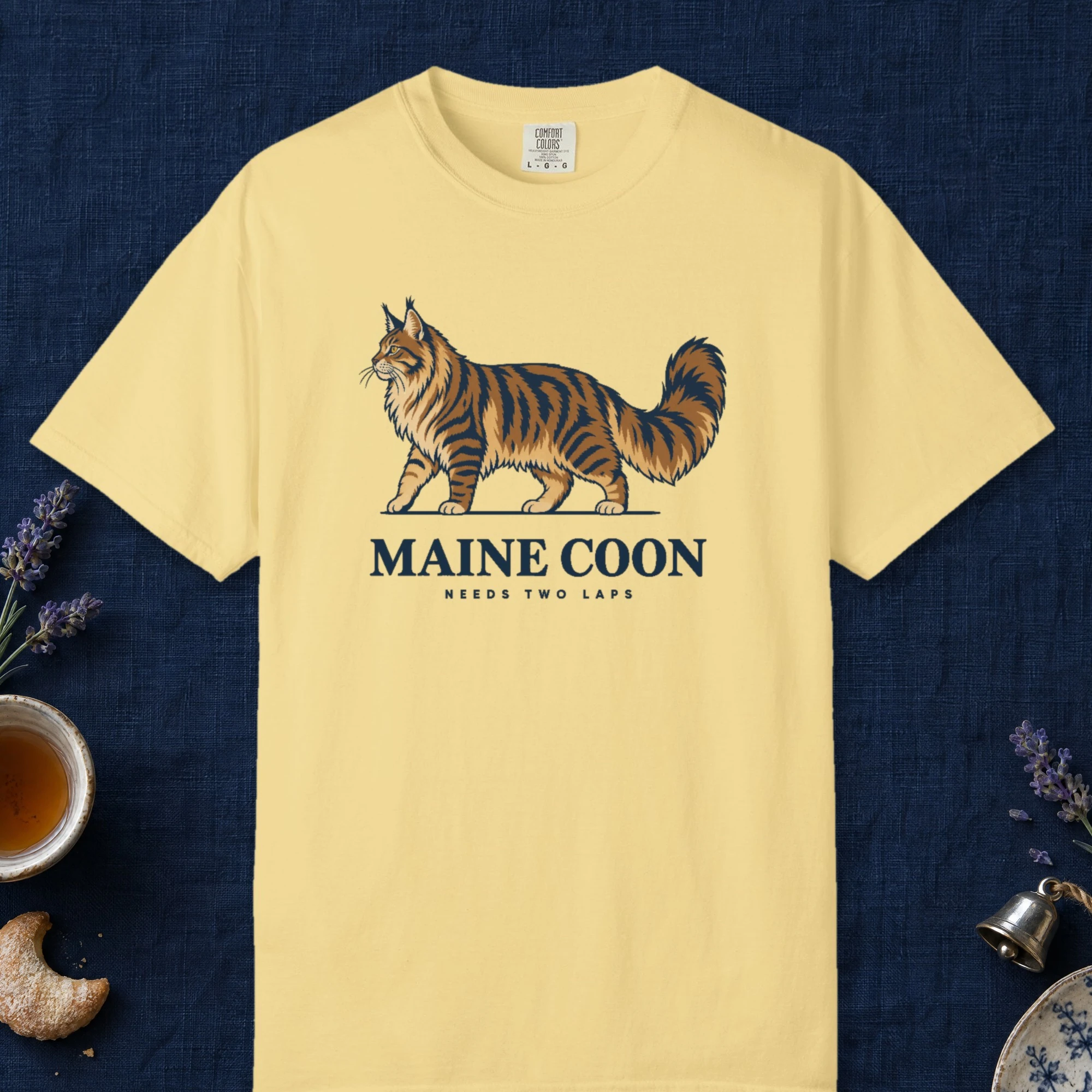 Maine Coon design on a Butter Comfort Colors 1717 tee, laid flat