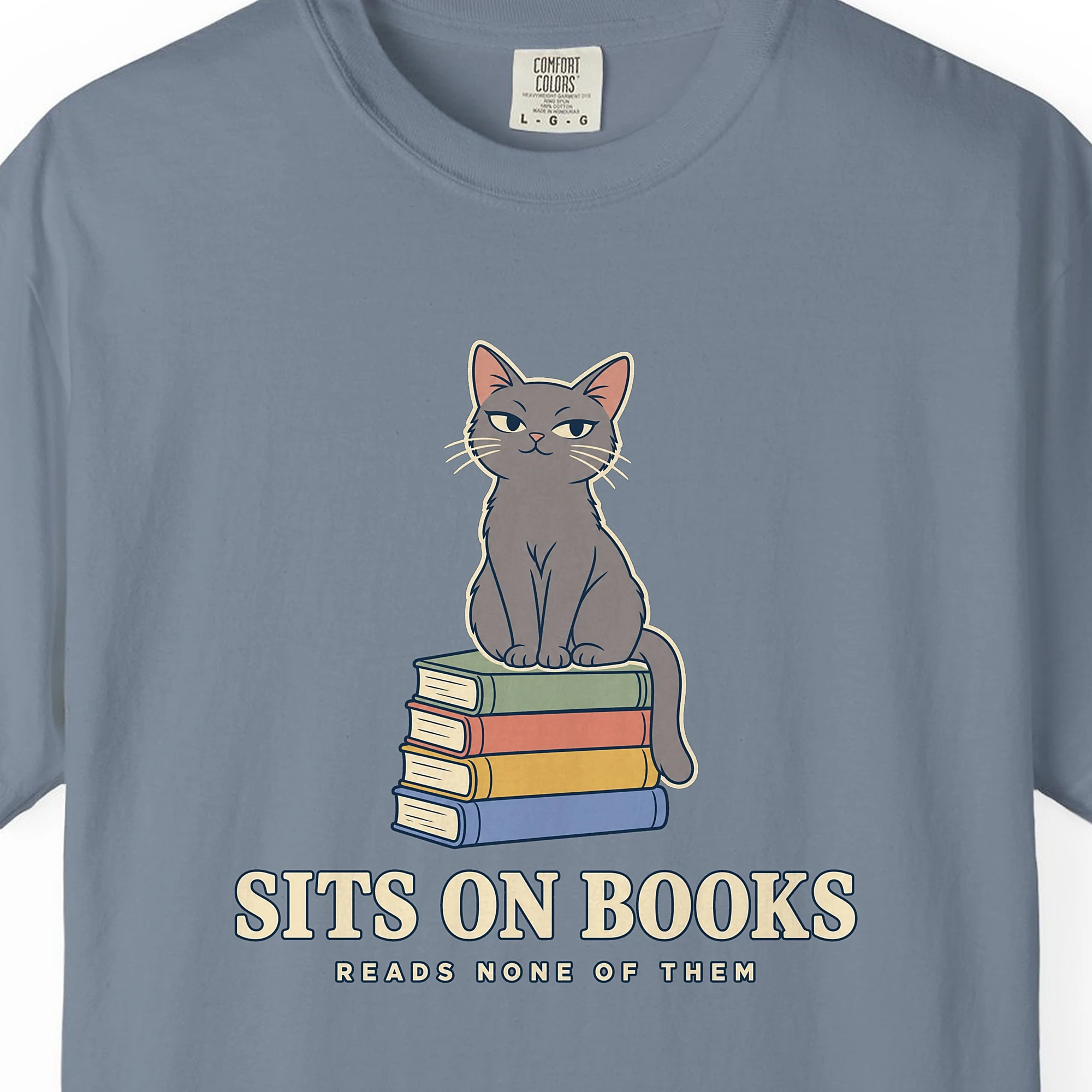 Close-up of the Sits on Books print on a Blue Jean Comfort Colors 1717 tee