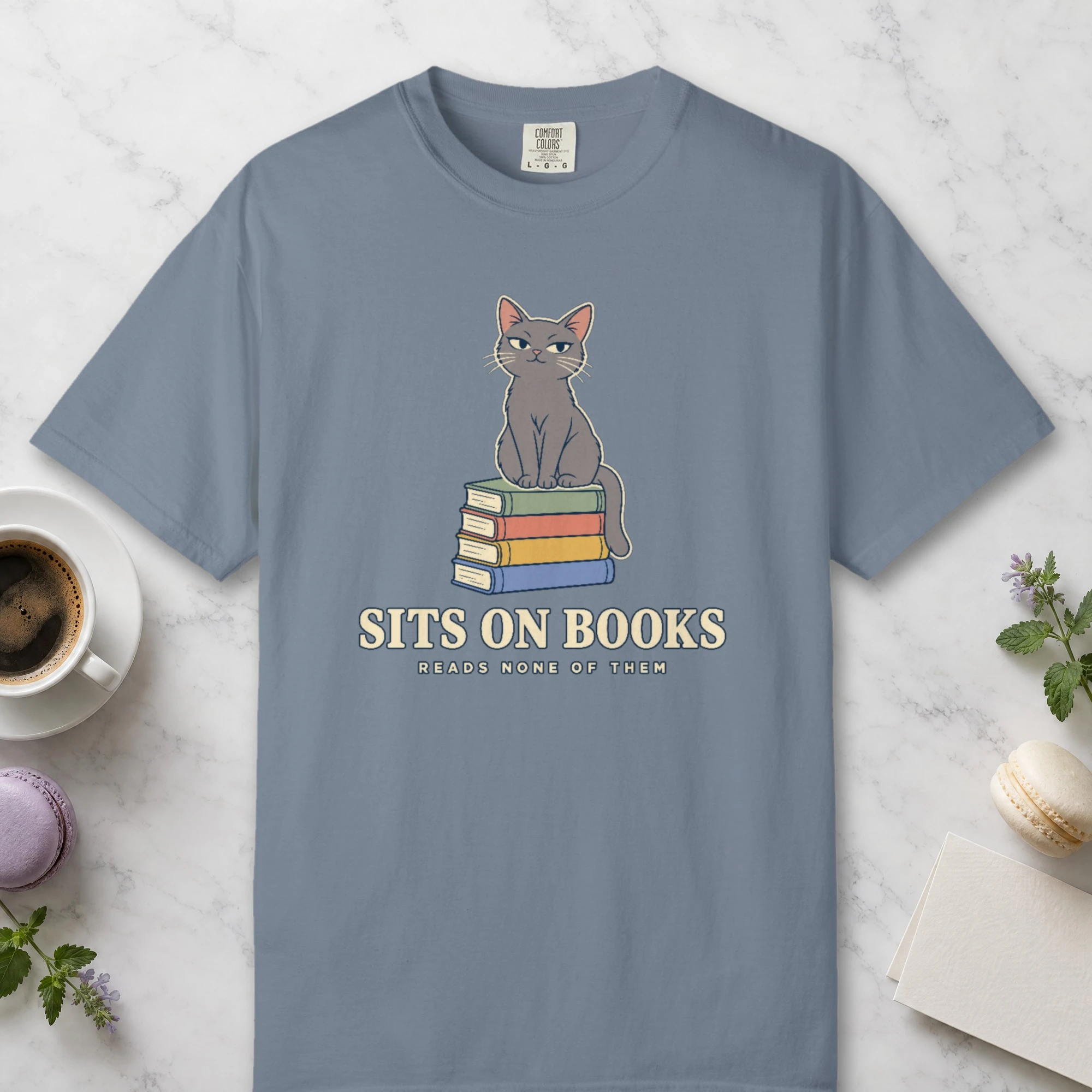 Sits on Books design on a Blue Jean Comfort Colors 1717 tee, laid flat