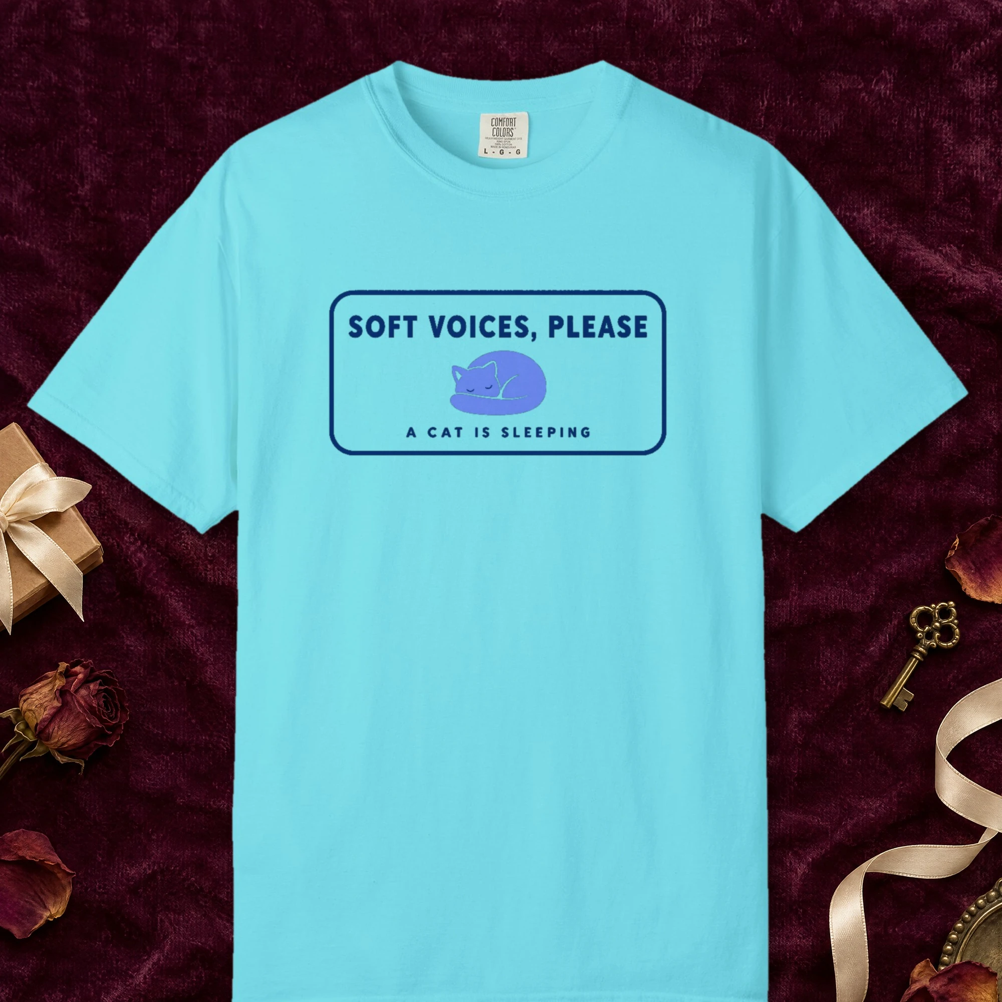 Soft Voices Please design on a Lagoon Blue Comfort Colors 1717 tee, laid flat