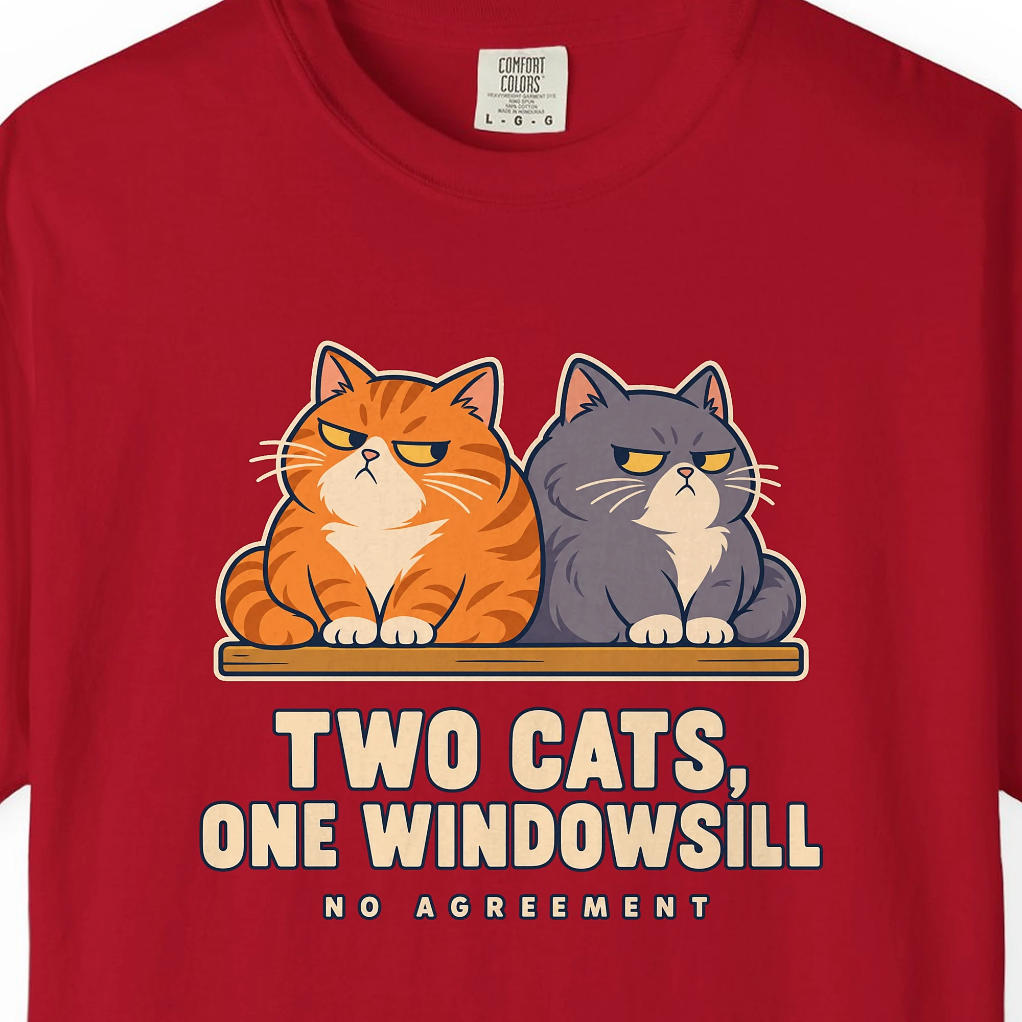 Close-up of the Two Cats One Windowsill print on a Red Comfort Colors 1717 tee